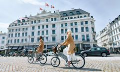 Visitors bike past D'Angleterre hotel in Copenhagen.